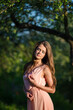 © zadorozhna - Beautiful young woman in green park.
