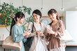 © buritora - Businesswomen (colleagues, bosses, subordinates) talking while looking at smartphones