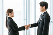 © buritora - Businessmen and women shaking hands in a corporate office to greet, introduce themselves and conclude a contract