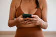 © Alberto/Stocksy - Woman in Workout Attire Uses Smartphone Indoors