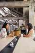 © Rob and Julia Campbell/Stocksy - Two women discussing business ideas at a modern open workspace table