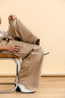 © Tania Cervian/Stocksy - Anonymous  man posing in beige pants and white boots