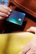 © Irina Bo/Stocksy - A hand takes out a bright credit card from a stylish handbag.