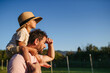 © Halfpoint - Dad carrying little boy on shoulders during warm summer day.