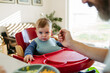 © Halfpoint - Caring father feeding toddler during mealtime at home.