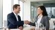 © Muhammad - A smiling businessman and businesswoman shaking hands in a modern office