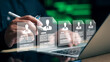 © Smile Studio AP - Business person reviewing digital resume profiles on laptop. Concept of recruitment, human resources, hiring, and online candidate selection.