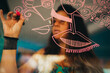 © Cavan Images - Female artist drawing dribbles on art studio window