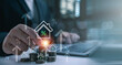 © Looker_Studio - Businessman hand putting coin on stack with virtual house and percentage icon. Conceptual for rising real estate interest rates, mortgage loan calculation, property tax, and financial investment.