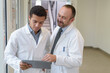 © auremar - senior and junior doctors looking at tablet pc
