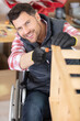 © auremar - disabled man assembling furniture in workshop