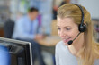 © auremar - smiling woman wearing telephone headset using computer
