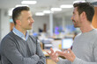 © auremar - two middle-aged men talking in office environment