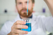 © auremar - scientist dropping solution from pipette into flask