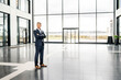 © Westend61 - Successful businessman standing in entrance hall of office building, with arms crossed