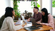 © Ladanifer - Diverse group of young people working together on projects at a wooden table