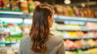 © realone952 - A rear view of a young woman examining products on store shelves