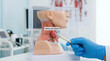 © Moonroad - Swollen lymph node model in clinical anatomy display held by gloved hand pointing with tool, educational medical demonstration showing neck anatomy and lymphatic swelling