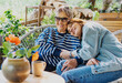 © olezzo - Happy senior mother and adult daughter laughing and hugging on a sunny home terrace