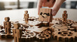 © RH Stock - Hand places handshake puzzle piece into complex gear system with wooden people figures
