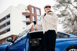 © Petro - Young woman standing outside her car in winter
