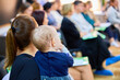 © Iurii Gagarin - Young caucasian mother holding baby at community event