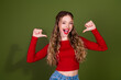 © deagreez - Young woman in red shirt smiles and thumbs up against a green background