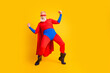 © deagreez - Dynamic superhero on yellow background performs energetic pose wearing red blue costume cape and mask