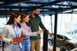 © djile - Salesperson helping couple choosing new car at dealership