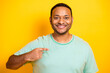 © deagreez - Smiling man points at himself wearing a casual tshirt against a bright yellow background
