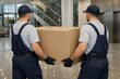 © Anzhelika - Two men working as movers carrying a large cardboard box together. Professional delivery service for home relocation or office moving concept.