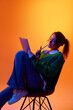 © master1305 - Creative professional sketching ideas on tablet in studio with vibrant gradient lighting. Concept of brainstorming session, concept development and focused digital content creation
