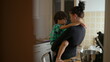 © Marco - Mother holding young boy in her arms, engaging in a tender and meaningful conversation in a warm kitchen setting, showcasing love and connection