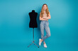 © deagreez - Young stylish woman with mannequin on blue studio background poses casually