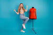 © deagreez - Young stylish woman jumps with excitement beside red turtleneck mannequin in studio