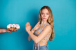 © deagreez - Young chic woman with blonde hair gestures as a plate of cookies is offered against a blue background