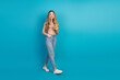 © deagreez - Young chic teen woman smiling holding yellow phone against blue background