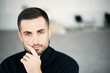 © GVS - Thoughtful man close-up looking to camera with copy space over modern interior background.