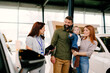 © djile - Happy family choosing new vehicle with sales consultant