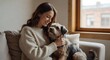 © Olga - Woman Cuddling Small Dog by Window at Home