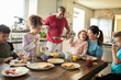 © Marko Geber - Parents and children eating breakfast together in home kitchen