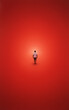 © Amanda - Lone figure illuminated by soft glow, standing against vivid red minimalist backdrop.