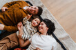© Nuria Seguí/Stocksy - Happy family lies on the floor