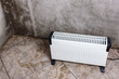 © Natallia - Modern portable electric heater, heating the basement. Drying the walls of a damp room.