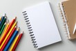 © Putra - Arrangement of Colorful Pencils and Notebooks on Neutral Background