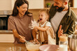 © La Famiglia - Family having fun baking, child playing with flour