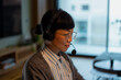 © Artcore Studio/Stocksy - Asian woman working remotely with headset from home