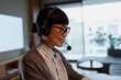 © Artcore Studio/Stocksy - Asian woman working in call center using headset