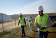 © Artcore Studio/Stocksy - Construction workers checking progress on a solar farm