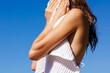 © Artem Podrez/Stocksy - Woman Drying Face With Towel Under Blue Sky